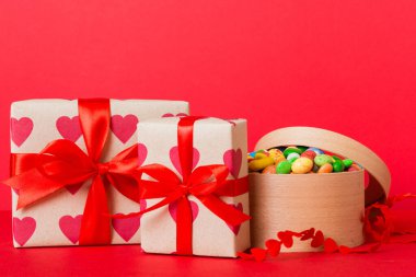 Valentine day composition: sweet candy, with gift boxes with bow and red felt hearts, photo template, background. Perspective with copy space.