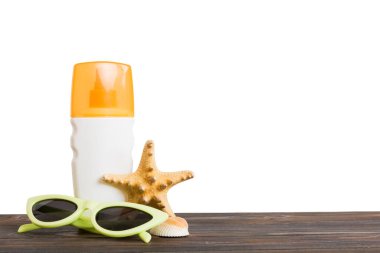 Profesyonel yaz yüz derisi. Nemlendirici sıvısı olan markasız bir kap. Krem ya da losyon. Yaz süslemeleri, deniz kabuğu ve deniz yıldızı, soyutlanmış arka planda. Metin için kopyalama alanı olan güzellik konsepti Perspektif görünümü.