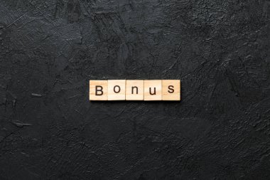 Tahta blokta bonus kelime yazıyor. Masada bonus metin, konsept.