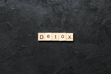 Tahta blokta yazan detoks kelimesi. Deksing, konsept için çimento masadaki detoks metni.
