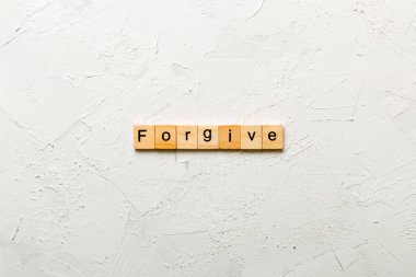 Forgive word written on wood block. Forgive text on cement table for your desing, Top view concept. clipart