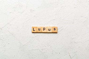 Lupus kelimesi tahta blokta yazılı. Masada lupus metni, konsept.