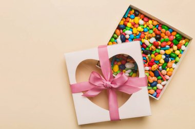 Box with sweet chocolate candies on color background, Various candy sweets. Valentines day gift box. Top view flat lay with copy space.