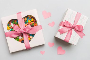 Valentine day composition: sweet candy, with gift boxes with bow and red felt hearts, photo template, background. Top View with copy space.