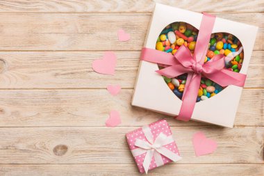 Valentine day composition: sweet candy, with gift boxes with bow and red felt hearts, photo template, background. Top View with copy space.