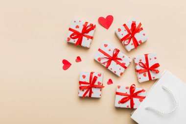 Gift boxes pop out from paper bag top view on colored background. bag packing handmade boxes fall out Concept of holidays, shopping, sale, discounts. Top view, flat lay.