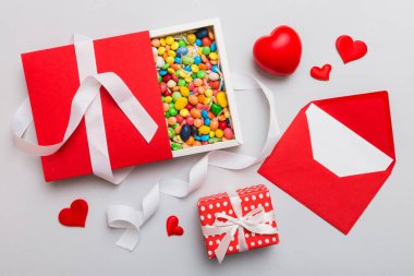 Valentine day composition: sweet candy, with gift boxes with bow and red felt hearts, photo template, background. Top View with copy space.