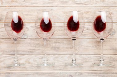 Şarap tadımında bir sürü kırmızı şarap. Renkli arka planda kırmızı şarap kavramı. Üst görünüm, düz dizayn.