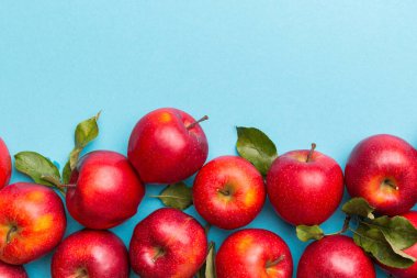 Renkli arka planda bir sürü kırmızı elma, üst manzara. Tasarım veya metin için kopyalama alanı olan taze elma görünümlü sonbahar deseni.