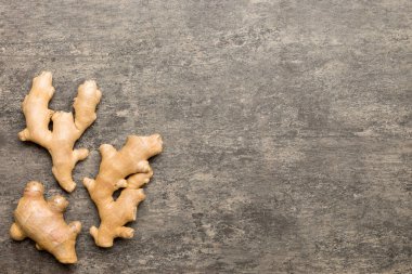Renkli arka planda yeşil yapraklı kabın içinde zencefil tozu var. Üst görünüm düzlüğü.