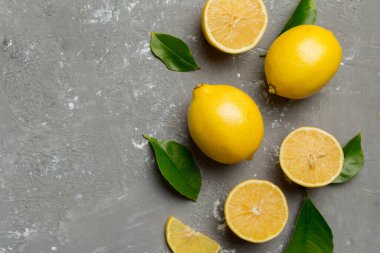 Renkli arka planda yeşil yapraklı taze limonlar, üst görünüm, metin için boşluk.