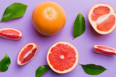Renkli arka planda sulu greyfurt dilimli taze meyve greyfurdu. Üst Manzara. Uzayı kopyala yaratıcı yaz konsepti. Minimum düzlükte turunçgillerin yarısı kopyalama alanı ile yatar.