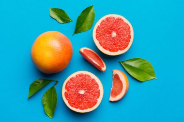 Renkli arka planda sulu greyfurt dilimli taze meyve greyfurdu. Üst Manzara. Uzayı kopyala yaratıcı yaz konsepti. Minimum düzlükte turunçgillerin yarısı kopyalama alanı ile yatar.