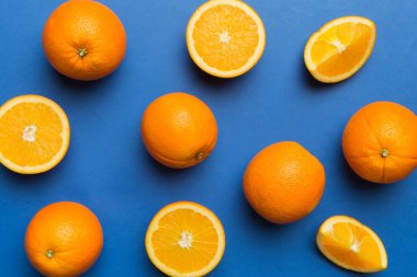 Renkli arka planda taze portakal dilimlerinin meyve deseni. Üst Manzara. Uzayı kopyala yaratıcı yaz konsepti. Minimum düzlükteki turunçgillerin yarısı.