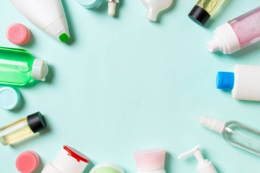 Plastik vücut bakım şişesi çerçevesi düz kompozisyonda renkli arka plan boşluğunda sizin tasarımınız için kozmetik ürünler sergileniyordu. Beyaz Kozmetik kapları kümesi, kopya alanı ile üst görünüm.