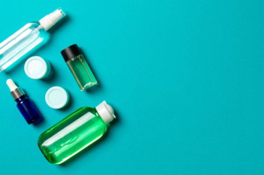 Kozmetik SPA marka modeli, fotokopi alanı olan üst görünüm. Renkli arka planda duran krema tüpleri ve kavanozları..