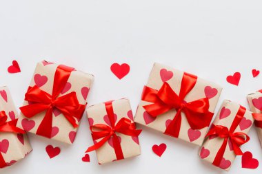 Top view photo of valentine day decorations gift box with red ribbon bow on colored background. Holiday gift boxes with top view.