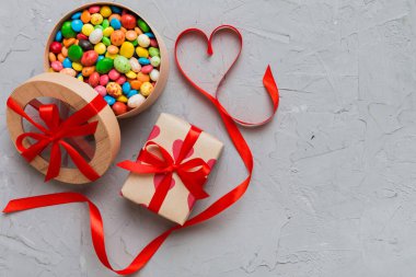 Valentine day composition: sweet candy, with gift boxes with bow and red felt hearts, photo template, background. Top View with copy space.