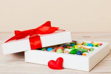 Valentine day composition: sweet candy, with gift boxes with bow and red felt hearts, photo template, background. Perspective with copy space.