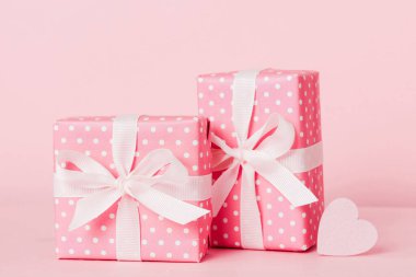 gift box with red bow and red heart on colored background. Perspective view. Flat lay.