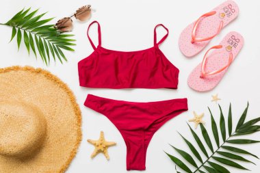 Kadın mayosu ve plaj aksesuarları düz manzarada yatıyordu. Renkli arka planda bikinili üst manzara. Tatil kavramı kopyalama alanı.