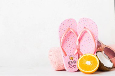 Plaj aksesuarları perspektifli terliklerin masa arkasına yerleştirilmiş üst görünüm kompozisyonu. Tropik yaz tatili konsepti.