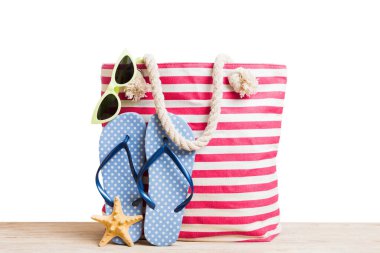 Plaj aksesuarlarıyla süslü bir çanta. Yaz tatili konsepti. Saman şapkalı plaj çantası, mesaj için yer var..