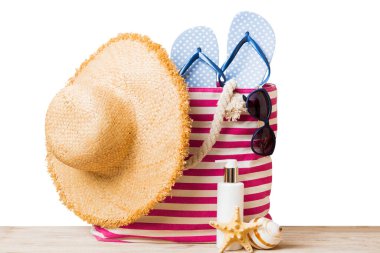 Plaj aksesuarlarıyla süslü bir çanta. Yaz tatili konsepti. Yazmak için alanı olan güneş kremi ile plaj çantasının üst görünümü.