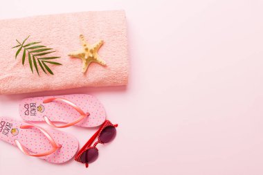 Yaz güneşlenme sahili arka planı, güneş gözlükleri, parmak arası terlikler ve havlu, metin için fotokopi alanı olan üstten manzara.