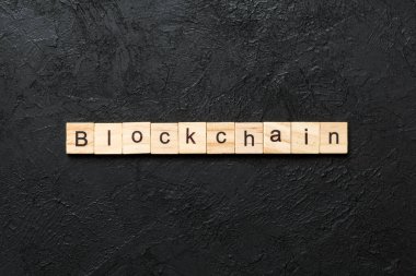 Tahta blokta bloklama kelimesi yazılı. Tablo üzerinde BLOCKCHAIN metni, konsept.