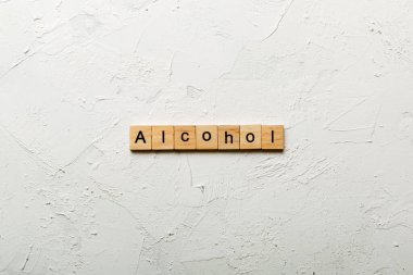 alcohol word written on wood block. alcohol text on table, concept. clipart