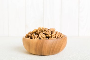 Fresh healthy walnuts in bowl on colored table background. Top view Healthy eating bertholletia concept. Super foods.