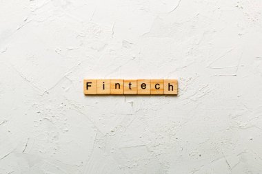 Tahta bloğa yazılmış FINTECH kelimesi. Çimento masasındaki FINTECH metni desing, konsept için.