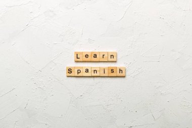 Tahta blokta yazılmış İspanyolca kelimeleri öğren. Masada İspanyolca metin, konsept öğrenin.