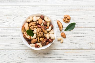 mixed nuts in bowl. Mix of various nuts on colored background. pistachios, cashews, walnuts, hazelnuts, peanuts and brazil nuts.