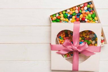 Box with sweet chocolate candies on color background, Various candy sweets. Valentines day gift box. Top view flat lay with copy space.