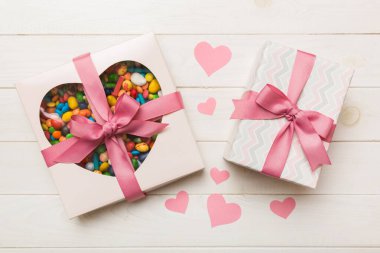 Valentine day composition: sweet candy, with gift boxes with bow and red felt hearts, photo template, background. Top View with copy space.