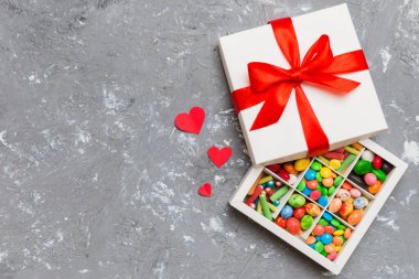 Valentine day composition: sweet candy, with gift boxes with bow and red felt hearts, photo template, background. Top View with copy space.