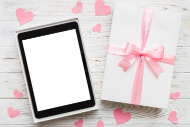 Gift box of open tablet for the holidays with a bow top view.