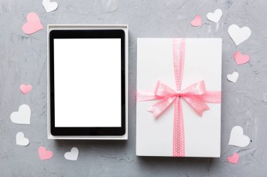 Gift box of open tablet for the holidays with a bow top view.