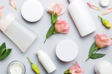 Renkli arka planda kozmetik ürünleri ve güzel güller olan kompozisyon. Düz yatıyordu.