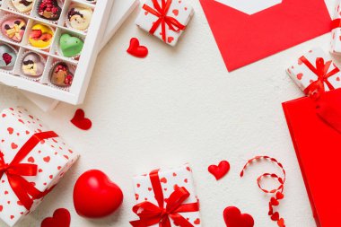 top view photo of st valentine day decor shopping, bag, envelope, gift, box, candy and red heart on colored background with empty space. Frame background.