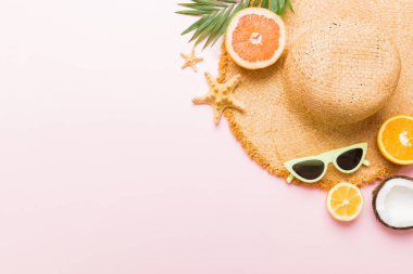 Renkli meyvelerin yanına yerleştirilmiş çeşitli deniz kabuklarının üst görüntüsü ve masa arkasında şık yaz aksesuarları. Yaz kavramı. Düz yatıyordu. Metin için kopyalama alanı olan üst görünüm.