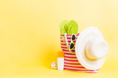 Plaj aksesuarlarıyla süslü bir çanta. Yaz tatili konsepti. Yazmak için alanı olan güneş kremi ile plaj çantasının üst görünümü.