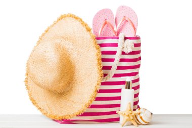 Plaj aksesuarlarıyla süslü bir çanta. Yaz tatili konsepti. Yazmak için alanı olan güneş kremi ile plaj çantasının üst görünümü.