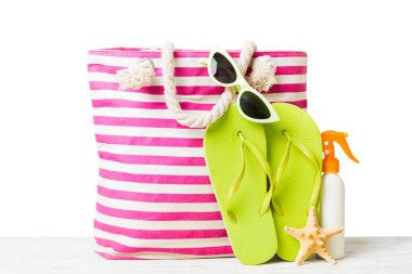 Plaj aksesuarlarıyla süslü bir çanta. Yaz tatili konsepti. Yazmak için alanı olan güneş kremi ile plaj çantasının üst görünümü.