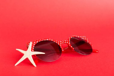 Masa arkasında deniz kabuğu olan güneş gözlükleri. Yaz arkaplanında güneş gözlüğü. Metin için kopyalama alanı olan üst görünüm düzlüğü.