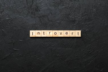 Introvert word written on wood block. Introvert text on table, concept. clipart