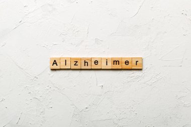 Tahta blokta Alzheimer kelimesi yazıyor. Alzheimer metni çimento masasında desing, konsept için.