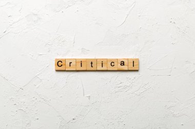 Tahta blokta kritik bir kelime yazıyor. masadaki kritik metin, konsept.